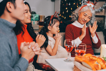 Happy multigeneration family enjoying in opening gifts on Christmas eve at home.