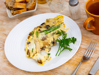 Delicious scrambled eggs with vegetables, chicken and mushrooms served for breakfast