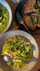 Socca / Farinata Chickpea flatbread and spinach Risotto on a wooden dining table. 