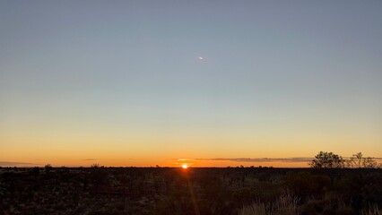 Sunrise in Uluru / Ayers Rock in a land of Buffel grass which is also known as bush grass and dry grass that grows in the land of red sand in Uluru.