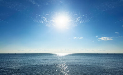 太陽の光を浴びてキラキラと光る海の波景色と美しい地平線