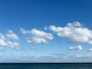 透き通った青い空に浮かもくもく雲と青い海