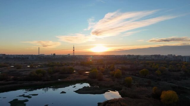 Aerial Side View of Vacaresti Delta at Sunset with Bucharest Cityscape in the Background, Romania