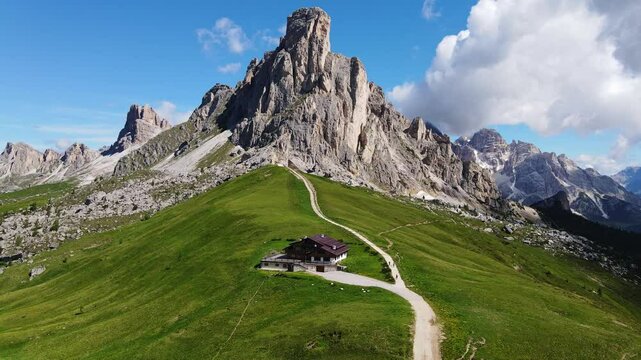 Drone glides over Passo Giau path - Ra Gusela rises majestically in background