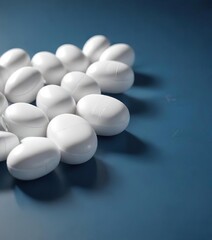 White pills arranged in a row on blue tabletop, treatment, healthcare, pharmaceuticals, medication, daily