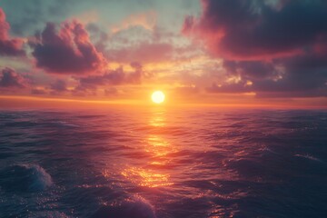 Obraz premium A serene sunset over a calm ocean, with vibrant colors reflecting on the water.