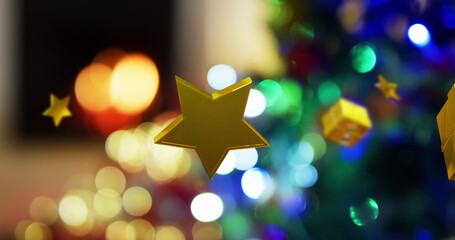 Gold stars and gifts floating over bokeh fire in fireplace and christmas lights on tree