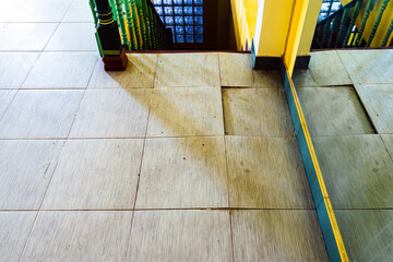 Background with falling off tiled tiles in living room. Close up of cracked ceramic tiles on a...