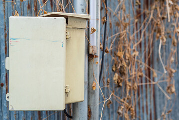 Utility box mounted on a post with a weathered metal background