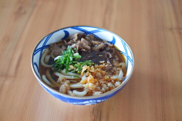 Rice noodle with beef in bowl on wooden table background.