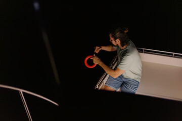 Adult caucasian male fishing on boat at night