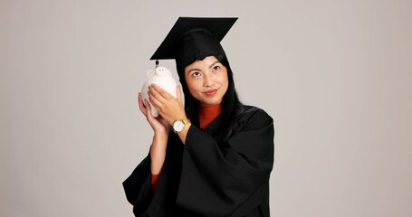 Woman, graduation and think with piggy bank in studio background for savings, financial aid or...