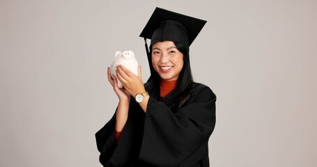 Woman, graduation and happy with piggy bank in studio background for savings, financial aid or...