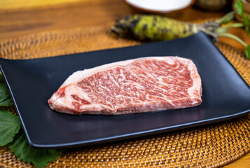 Fresh A5 Japanese Wagyu Beef Grading on black plate, Raw Japanese premium grade A5 Wagyu marble beef.