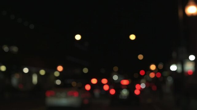 Night traffic bokeh in urban setting blurred view of city streetlights and car tail lights at night, showcasing dynamic bokeh effect in urban environment Night traffic bokeh ity street lights