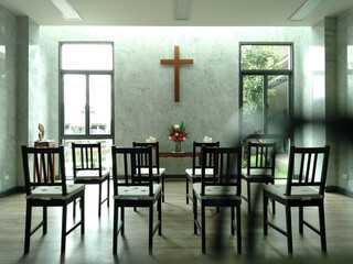 Empty chairs in chapel awaiting worshippers with sunlight streaming through windows.