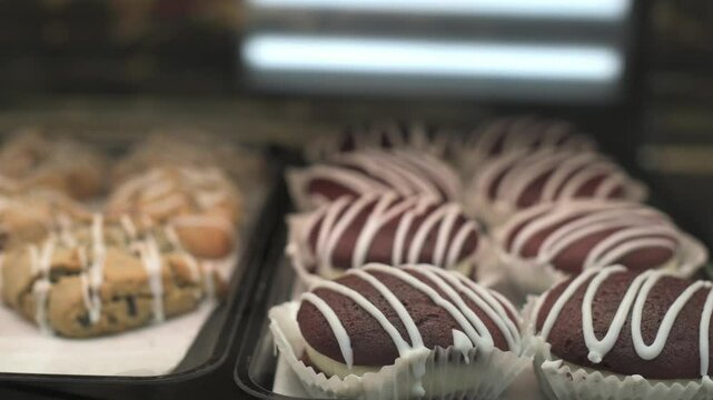 Close-up of delectable red velvet pastries with white icing drizzle displayed in bakery, showcasing their rich texture and sweet appeal red velvet pastries with white icing drizzle displayed in bakery