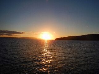 Naklejka premium The sun is slowly setting over a tranquil body of water nearby Whitsunday Island, Queensland, Australia