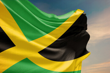 Waving flag of Jamaica in blue sky. Jamaica flag on pole for Independence Day. The symbol of the state on wavy fabric.
