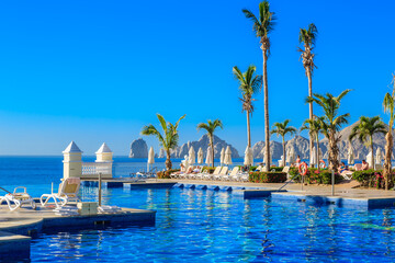 A beautiful pool with palm trees and umbrellas