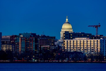 Obraz premium Downtown Madison, WI and the Wisconsin State Capitol Building behind Lake Monona at Twilight
