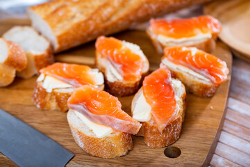 Delicious sandwiches with salmon and butter on a white plate