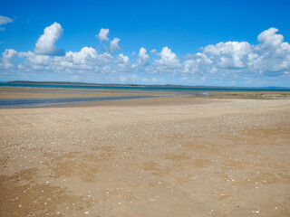 A beach scene with a blue sky and fluffy white clouds Hervey Bay Fraser Australia