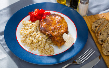 Plate of tasty roasted beef steak with barley porridge and roasted pepper