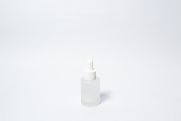 White dropper glass bottle with white liquid inside on isolated white background