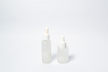 White dropper glass bottle with white liquid inside on isolated white background