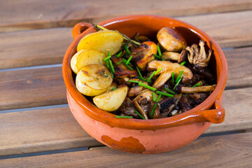 Close-up of delicious different mushrooms cooked with potatoes at clay pot