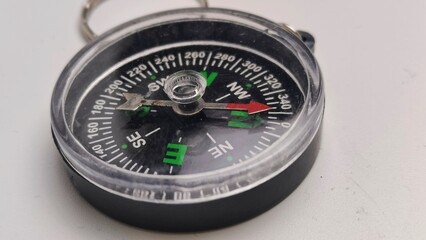 mini compass needle pointing to north on isolated white background