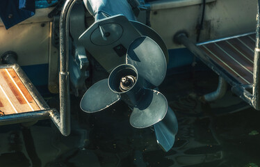 Motorboat screw sticks out of the water.

Ship's propeller at rest in close-up.
A marine...