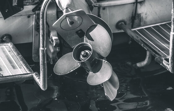 Motorboat screw sticks out of the water.

Ship's propeller at rest in close-up.
A marine propeller
at the lake in summer.
