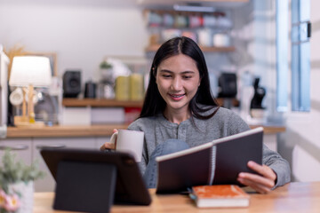 Fototapeta premium Female business freelancer asian person using digital tablet and laptop or remote working at home office, 