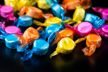 黒背景にたくさんのカラフルなラムネ菓子