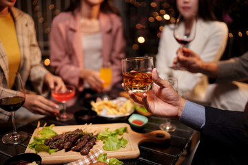 Party Celebrate whiskey at a friendly party in a restaurant. Night.