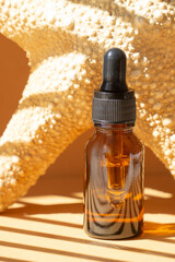 Amber glass retinol serum brown bottles on brown background with starfish.