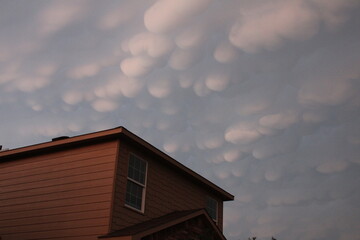 Blue sky with puffy clouds and house