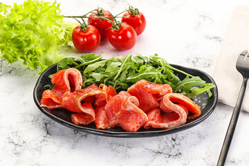 Sliced salmon with fresh arugula