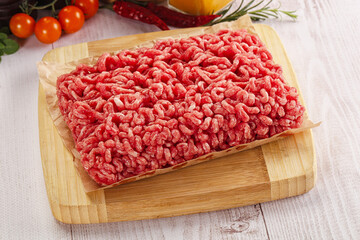Raw minced beef meat over board