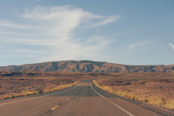 Endless road in the desert with a mountain backdrop in USA