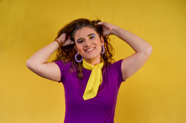 Fototapeta premium Young woman holding her hair smiling on yellow background