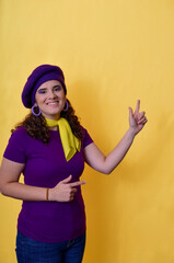 Naklejka premium Young woman pointing up and smiling on yellow background