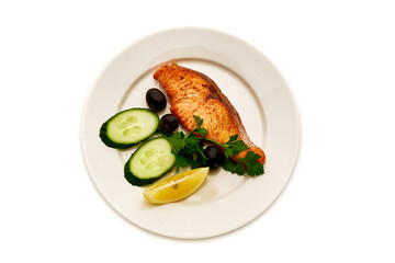 A plate of food with a piece of salmon, cucumber, and lemon