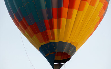 Fototapeta premium A hot air balloon with a colorful pattern is floating in the sky