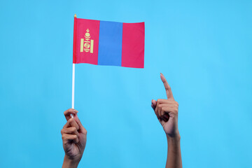 Raised Hands Holding And Pointing Mongolia National Flag Isolated on Blue Background