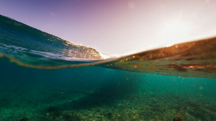 Ocean wave breaks on a shore in the Maldives on sunset