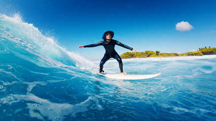 Surfer skillfully riding powerful ocean waves on a bright sunny day. Maldives