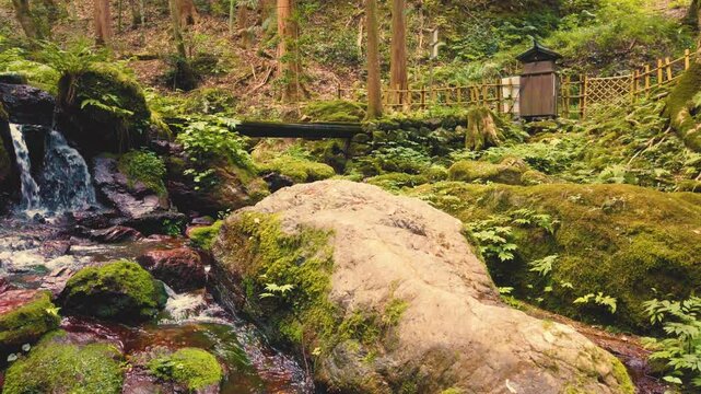 Japanese zen cascade, water stream landscape in moss stone relaxing cascade